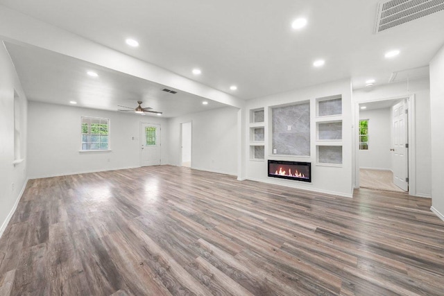 7309 Blessing Ave, Austin, TX 78752 - unfurnished living room with wood finished floors, recessed lighting, ceiling fan, a glass covered fireplace, and built in features