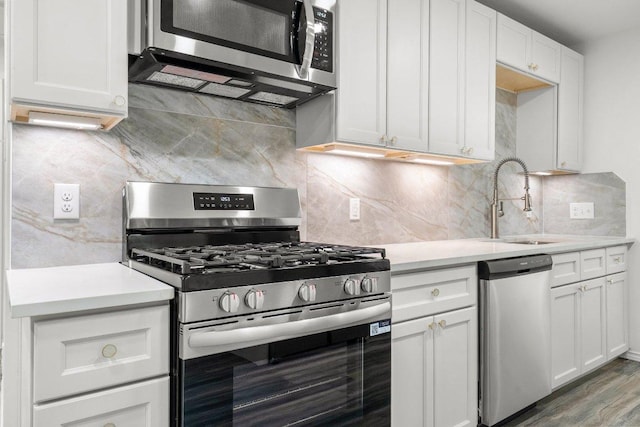 7309 Blessing Ave, Austin, TX 78752 - kitchen featuring stainless steel appliances, light countertops, decorative backsplash, and white cabinets