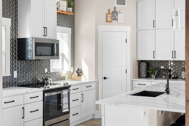 TBD Fm 3000, Elgin, TX 78621 - kitchen with stainless steel appliances, tasteful backsplash, light stone counters, and white cabinets