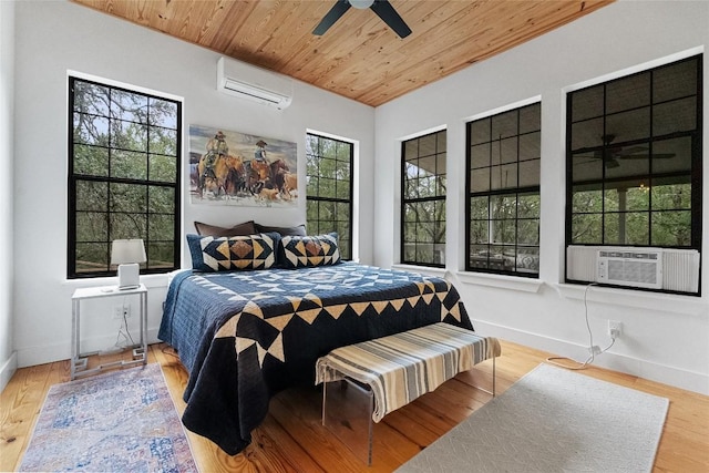 415 Balch Rd, Elgin, TX 78621 - bedroom featuring a wall unit AC, wood ceiling, cooling unit, wood finished floors, and a ceiling fan