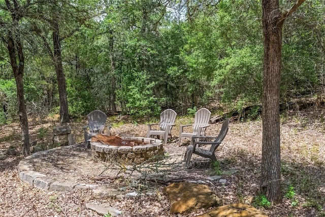 415 Balch Rd, Elgin, TX 78621 - view of patio featuring an outdoor fire pit and a wooded view