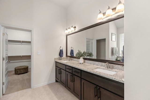 232 Silver Pass, Kyle, TX 78640 - bathroom with double vanity, a spacious closet, and tile patterned flooring
