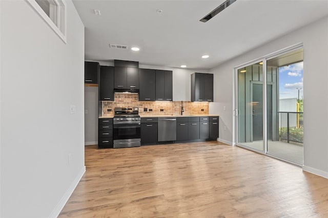 4510 Terry-O Ln Unit 205, Austin, TX 78745 - kitchen featuring appliances with stainless steel finishes, dark cabinetry, light countertops, backsplash, and light wood finished floors