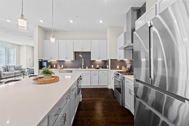 4501 Jackson Ave Unit 5301, Austin, TX 78731 - kitchen with appliances with stainless steel finishes, wall chimney range hood, light countertops, backsplash, and dark wood finished floors