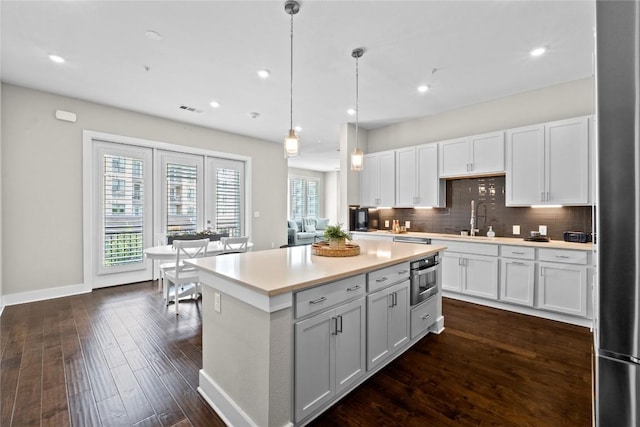 4501 Jackson Ave Unit 5301, Austin, TX 78731 - kitchen featuring light countertops, dark wood-style floors, backsplash, white cabinets, and recessed lighting