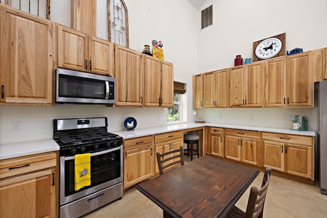 705 Peregrine Way, Leander, TX 78641 - kitchen featuring stainless steel appliances, a high ceiling, and light countertops