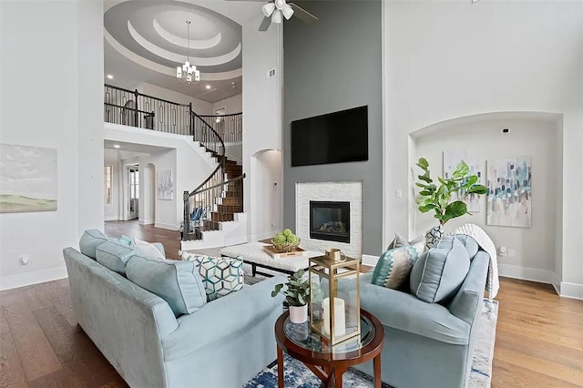 108 Rio Ranchero Rd, Georgetown, TX 78628 - living area with wood finished floors, a towering ceiling, ceiling fan, stairs, and a glass covered fireplace