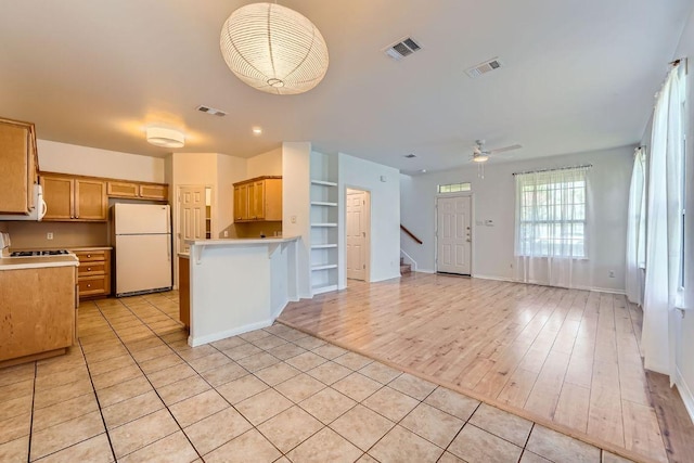 2920 Thrushwood Dr, Austin, TX 78757 - kitchen featuring freestanding refrigerator, open floor plan, ceiling fan, a peninsula, and light countertops