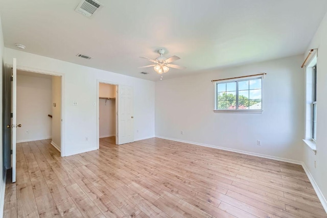 2920 Thrushwood Dr, Austin, TX 78757 - unfurnished bedroom with light wood-style floors, ceiling fan, a walk in closet, and a closet