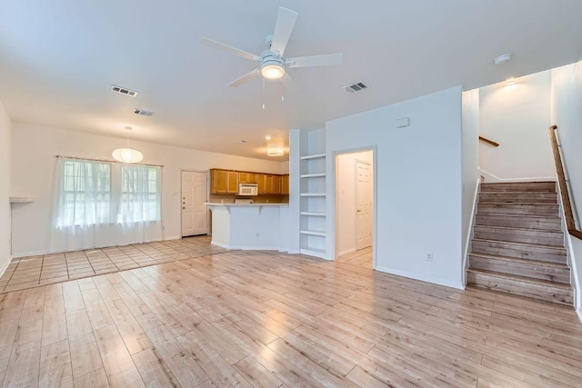 2920 Thrushwood Dr, Austin, TX 78757 - unfurnished living room featuring light wood-style flooring, built in shelves, ceiling fan, and stairway