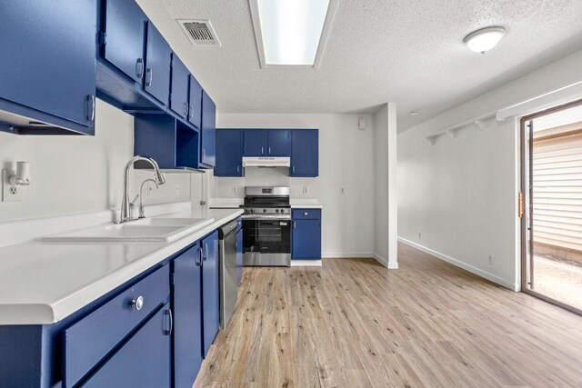 3050 Beacon Fld, San Antonio, TX 78245 - kitchen with appliances with stainless steel finishes, blue cabinetry, under cabinet range hood, a textured ceiling, and light wood finished floors