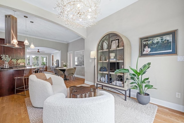 4206 Sinclair Ave, Austin, TX 78756 - living room featuring arched walkways, light wood-style floors, a chandelier, a ceiling fan, and crown molding