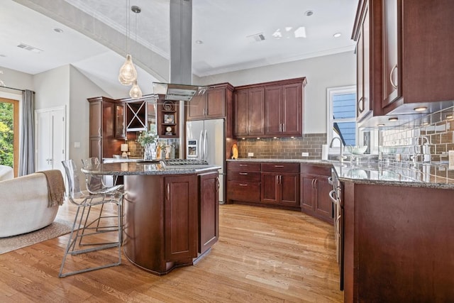 4206 Sinclair Ave, Austin, TX 78756 - kitchen featuring light wood-style floors, dark stone counters, stainless steel fridge with ice dispenser, a breakfast bar, and tasteful backsplash