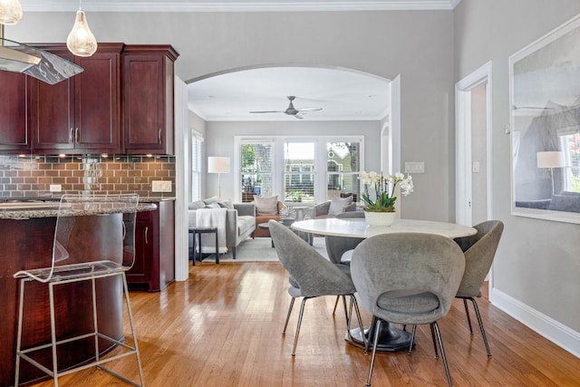 4206 Sinclair Ave, Austin, TX 78756 - dining area with arched walkways, crown molding, light wood-style floors, and a ceiling fan