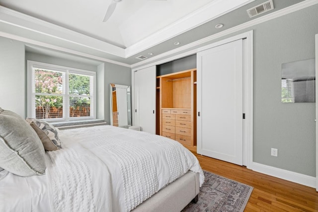 4206 Sinclair Ave, Austin, TX 78756 - bedroom featuring wood finished floors, a tray ceiling, a ceiling fan, and crown molding