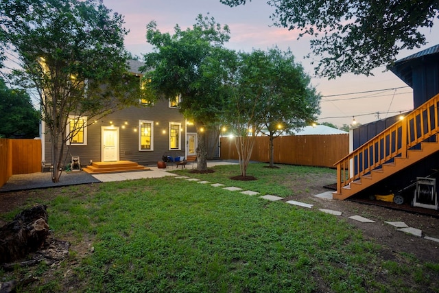 607 W 32nd St, Austin, TX 78705 - back of house at dusk featuring a fenced backyard, a patio, and stairs