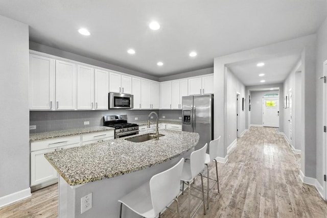 9108 Alex Ln, Austin, TX 78748 - kitchen with appliances with stainless steel finishes, light wood-style floors, white cabinets, and recessed lighting
