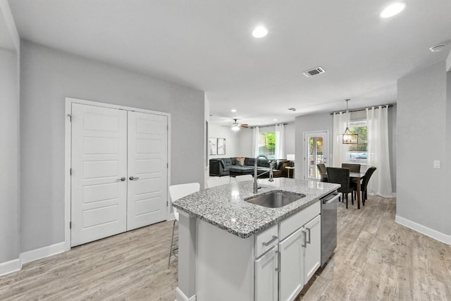 9108 Alex Ln, Austin, TX 78748 - kitchen with dishwasher, light wood-style floors, recessed lighting, a kitchen island with sink, and white cabinetry