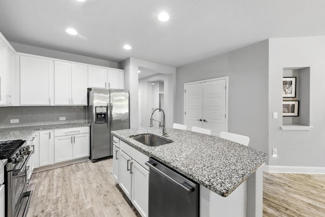 9108 Alex Ln, Austin, TX 78748 - kitchen featuring appliances with stainless steel finishes, light wood-style flooring, white cabinets, and recessed lighting