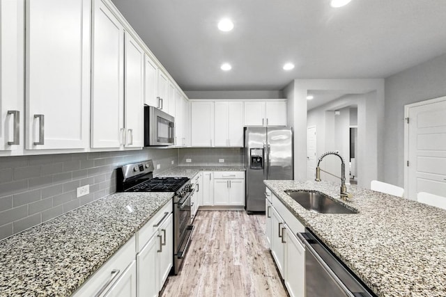 9108 Alex Ln, Austin, TX 78748 - kitchen with appliances with stainless steel finishes, white cabinetry, tasteful backsplash, light stone counters, and recessed lighting