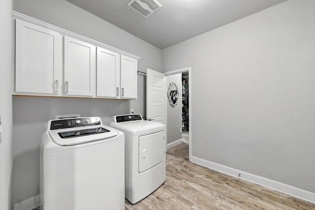 9108 Alex Ln, Austin, TX 78748 - laundry area featuring cabinet space, washer and dryer, and light wood-style floors