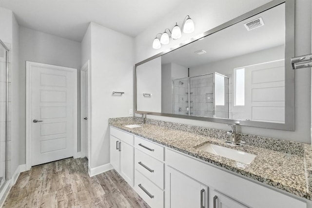 9108 Alex Ln, Austin, TX 78748 - full bath featuring a shower stall, double vanity, and wood finished floors
