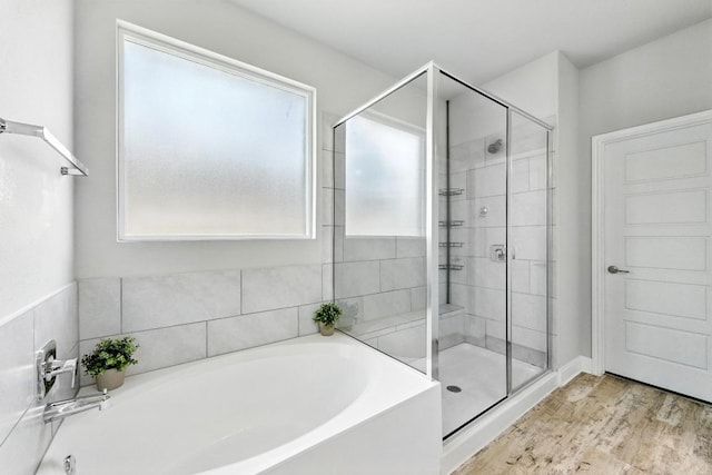 9108 Alex Ln, Austin, TX 78748 - bathroom featuring a bath, a shower stall, and wood finished floors