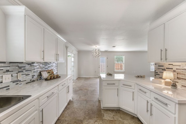 6828 Walkup Ln, Austin, TX 78747 - kitchen featuring white cabinets, a peninsula, backsplash, and plenty of natural light