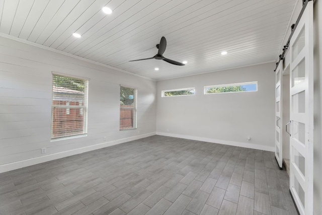 6828 Walkup Ln, Austin, TX 78747 - empty room featuring a barn door, ceiling fan, wood ceiling, healthy amount of natural light, and recessed lighting