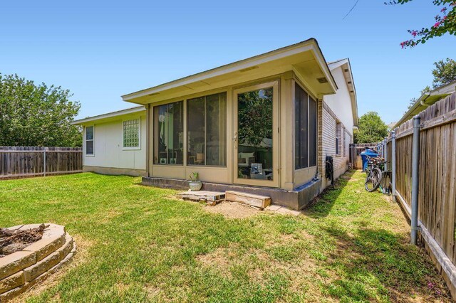 803 Hank Aaron Ln, Round Rock, TX 78665 - rear view of house with a fenced backyard and a sunroom