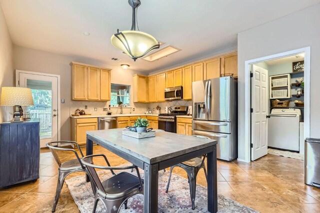 803 Hank Aaron Ln, Round Rock, TX 78665 - kitchen featuring stainless steel appliances, washer / dryer, light brown cabinetry, and healthy amount of natural light