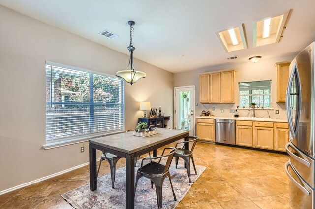 803 Hank Aaron Ln, Round Rock, TX 78665 - kitchen with stainless steel appliances, light brown cabinets, light countertops, and tasteful backsplash