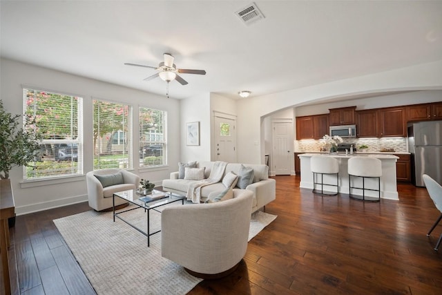 11013 Avery Station Loop Unit 31, Austin, TX 78717 - living room featuring arched walkways, a ceiling fan, and dark wood finished floors