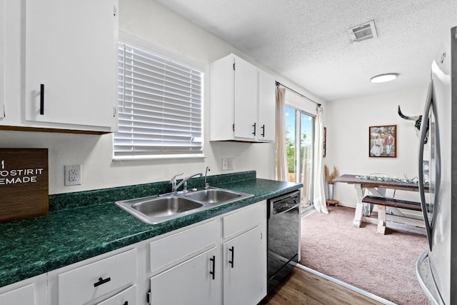 8104 Bronco Ln, Lago Vista, TX 78645 - kitchen featuring dishwashing machine, freestanding refrigerator, white cabinets, dark countertops, and a textured ceiling