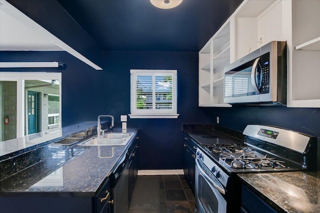 1210 Windsor Rd Unit 113, Austin, TX 78703 - kitchen with appliances with stainless steel finishes, dark tile patterned floors, and dark stone countertops