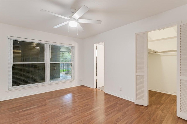 1210 Windsor Rd Unit 113, Austin, TX 78703 - unfurnished bedroom with a walk in closet, wood finished floors, ceiling fan, and a closet