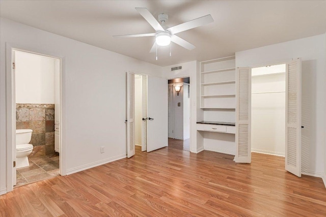 1210 Windsor Rd Unit 113, Austin, TX 78703 - unfurnished bedroom with light wood-style flooring, tile walls, ensuite bath, and ceiling fan
