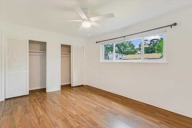 1210 Windsor Rd Unit 113, Austin, TX 78703 - unfurnished bedroom with two closets, light wood-type flooring, and ceiling fan