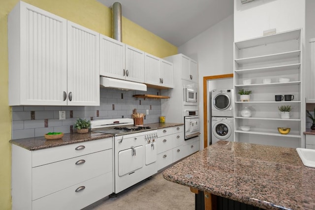 913 Taulbee Ln, Austin, TX 78757 - kitchen with estacked washer and dryer, open shelves, under cabinet range hood, decorative backsplash, and dark stone counters