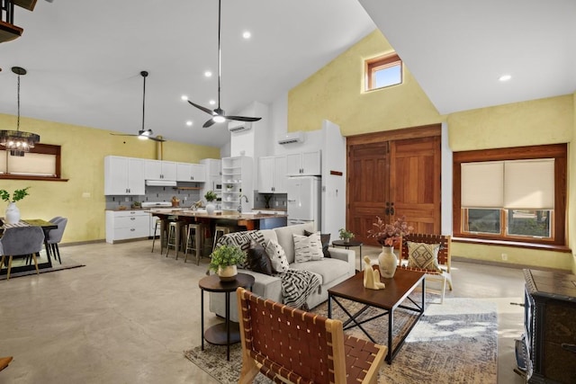 913 Taulbee Ln, Austin, TX 78757 - living room with high vaulted ceiling, concrete floors, ceiling fan, and a chandelier