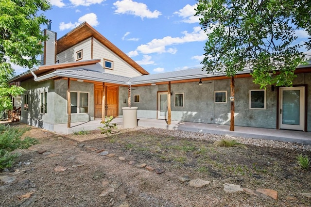 913 Taulbee Ln, Austin, TX 78757 - rear view of property with a patio area, stucco siding, a metal roof, ceiling fan, and a chimney