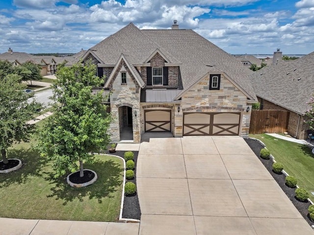 1113 Hartman Dr, Leander, TX 78641 - french country home with stone siding, driveway, a standing seam roof, a chimney, and a shingled roof
