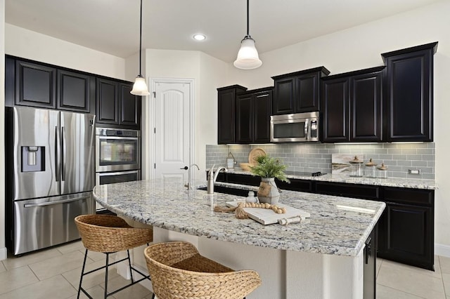 1113 Hartman Dr, Leander, TX 78641 - kitchen with appliances with stainless steel finishes, dark cabinetry, light tile patterned floors, decorative backsplash, and recessed lighting