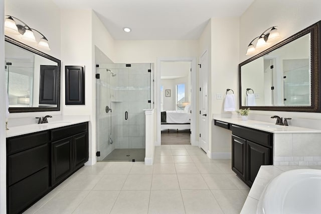 1113 Hartman Dr, Leander, TX 78641 - full bathroom with a shower stall, two vanities, tile patterned flooring, and a bath