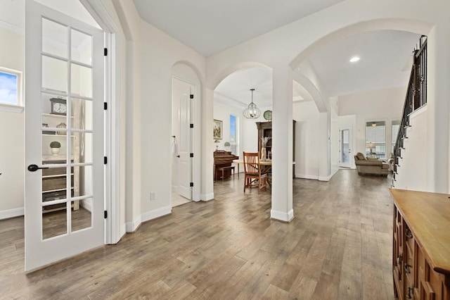 1113 Hartman Dr, Leander, TX 78641 - entrance foyer featuring arched walkways, wood finished floors, stairs, recessed lighting, and a chandelier