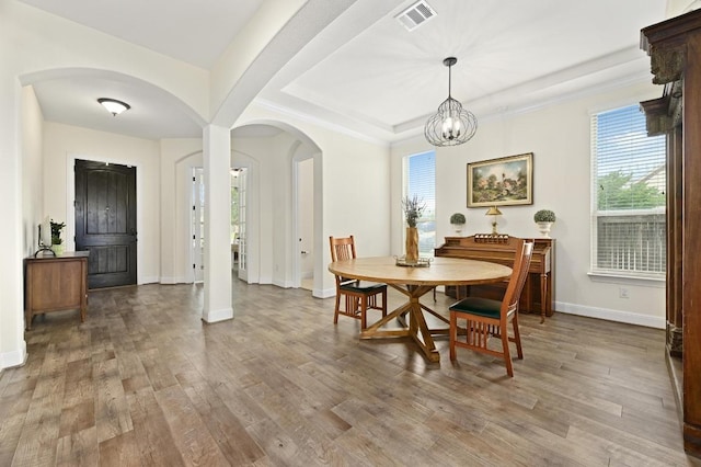 1113 Hartman Dr, Leander, TX 78641 - dining area featuring arched walkways, plenty of natural light, wood finished floors, and a chandelier