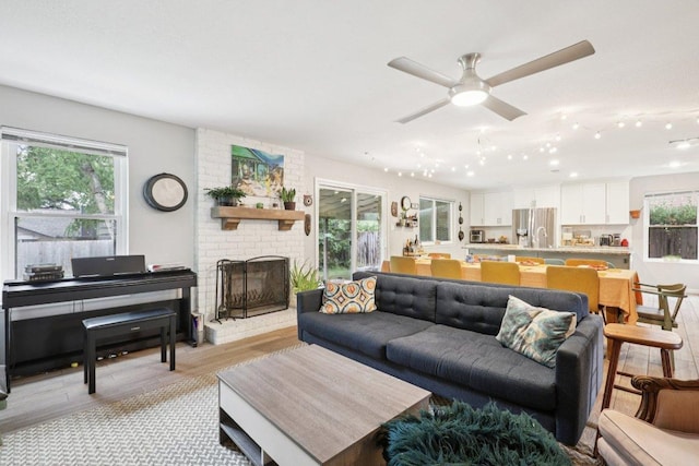 6803 Moonmont Dr, Austin, TX 78745 - living room featuring plenty of natural light, a ceiling fan, light wood-type flooring, and a brick fireplace