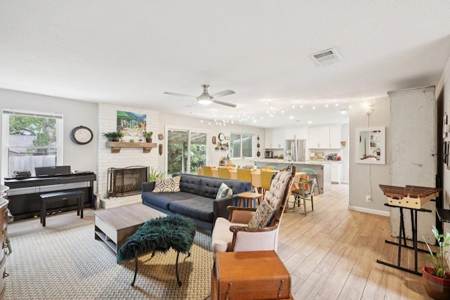 6803 Moonmont Dr, Austin, TX 78745 - living room with a ceiling fan, a fireplace, and light wood-style floors