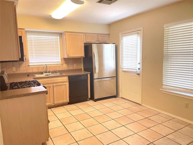 8501 Bismark Cv, Austin, TX 78745 - kitchen with dishwasher, freestanding refrigerator, light tile patterned flooring, gas range, and backsplash