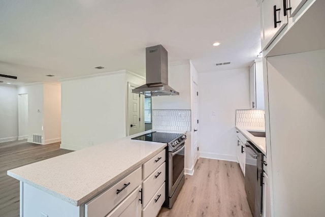 6102 Amber Pass, Austin, TX 78745 - kitchen featuring appliances with stainless steel finishes, island range hood, light wood-type flooring, recessed lighting, and white cabinets